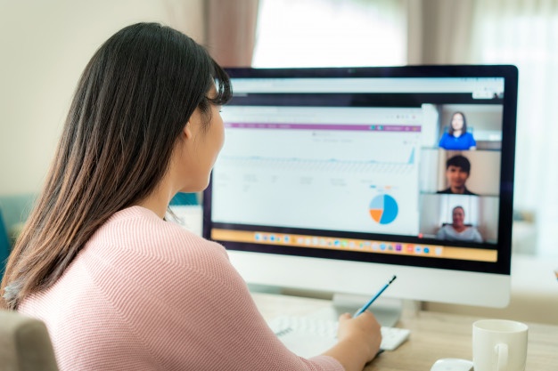 back view of asian woman talking with colleagues virtually