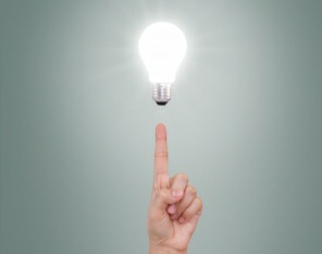 Index finger pointing illuminated bulb