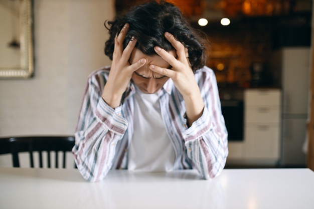 Frustrated unhappy young man holding his head with his hands