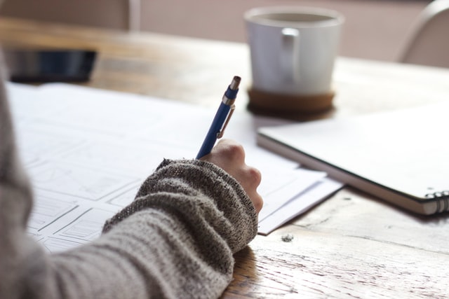 Woman holding pen to write