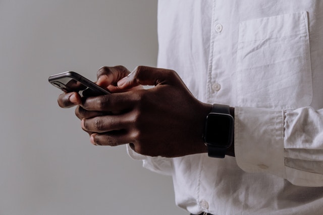 Black man pressing a smartphone