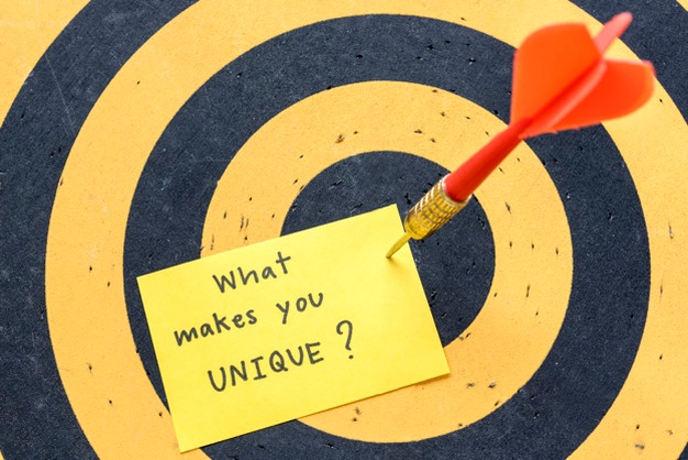 Red arrow pinning down a sticker note on a yellow and black target board