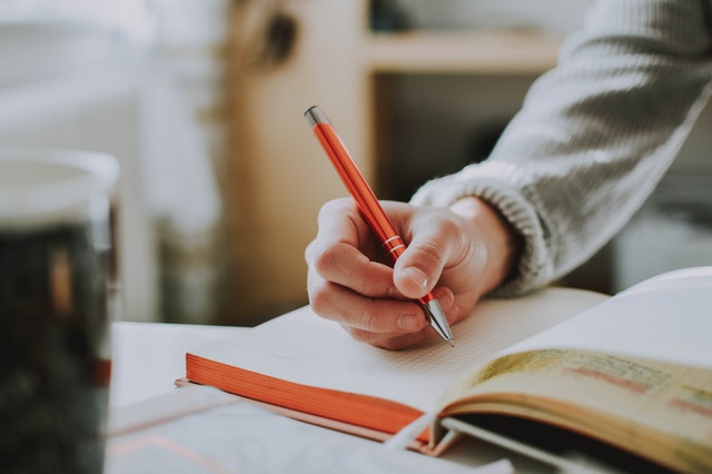 Hand of a lady in a writing position