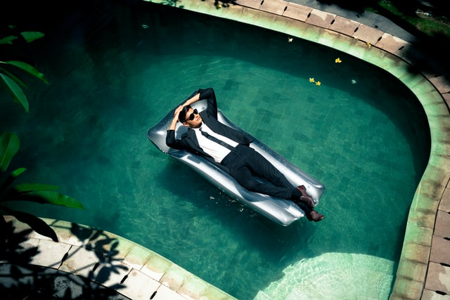 Man wearing suit relaxing in a swimming pool