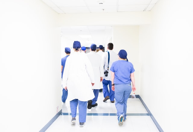 Medical personnel's walking in groups n blue and white scrubs