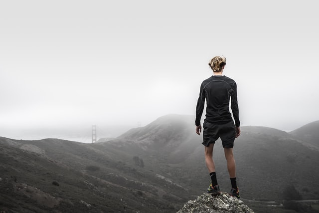 Young man standing on a foggy hill